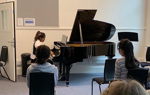 Student playing a piano.