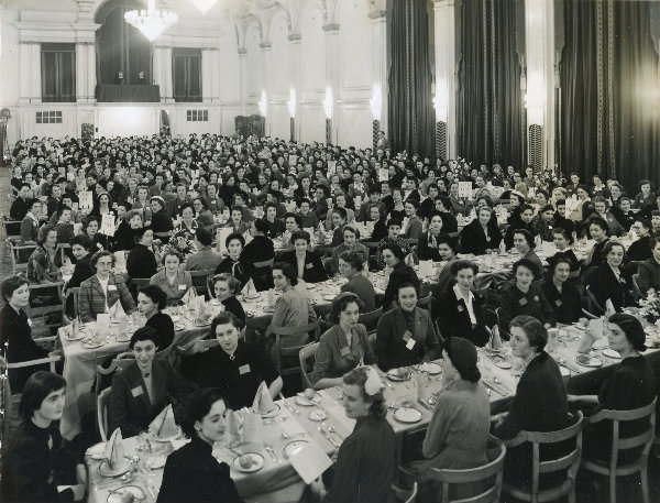 Old photograph of students gathered eating dinner in the Great Hall.