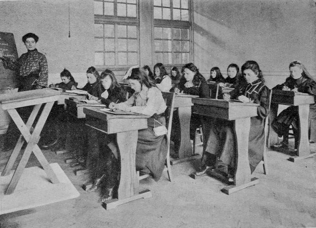 First students studying at their desks in a classroom in 1904.