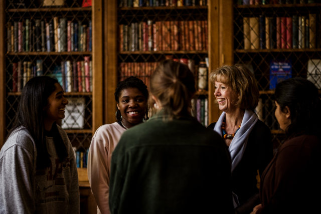 High Mistress Sarah Fletcher with students in the library.