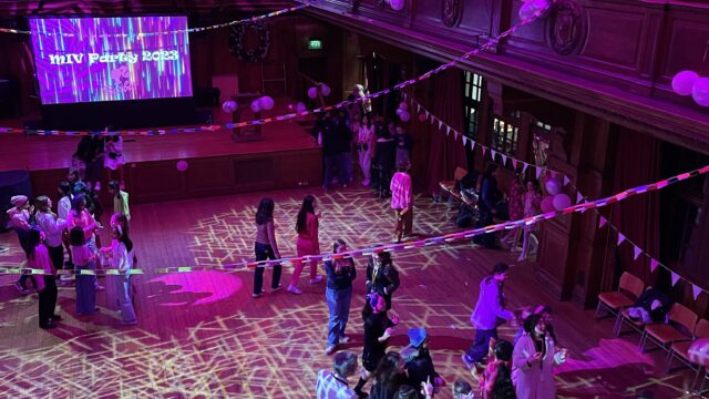 Students in the Great Hall with pink lights at the MIV Party