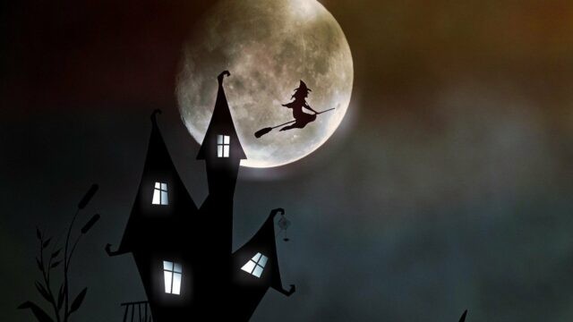 A witch on a broomstick flying over a house
