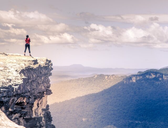 Woman standing on top of a mountain looking onto the valley